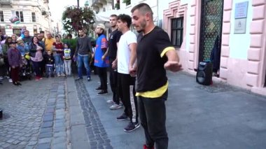 LVIV, UKRAINE - SEPTEMBER 15, 2019: Unknown guys dance break on the street of the city.