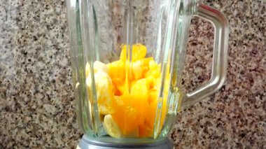 Bir kivinin, portakalların ve muzların mikserini dolduruyorum..