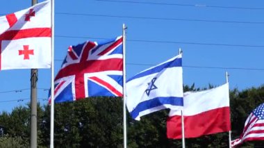 Bayrak direkleri üzerinde Belarus, Gürcistan, İngiltere, İsrail, Polonya, Usa, Özbekistan ve Ukrayna bayrakları.