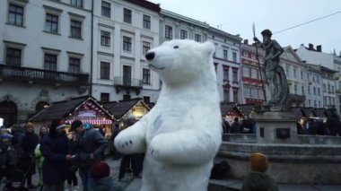 Lviv, Ukrayna - 25 Aralık 2019: Dev bir kutup ayısı kıyafetleri içindeki sokak sanatçısı şehir meydanında halkı eğlendiriyor.