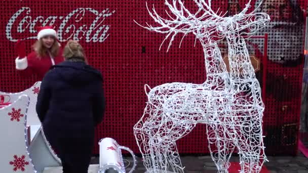 ウクライナのリヴィウ 2019年12月21日 知られていない人々は コーラクリスマス広告の背景に鹿とそりで撮影されています — ストック動画