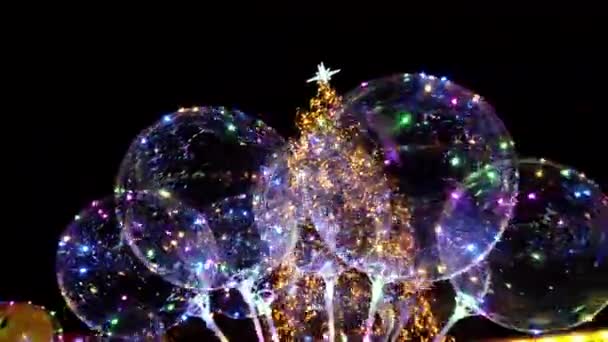 Ballonnen Met Bloemenslingers Tegen Achtergrond Van Kerstboom Geleide Transparante Ballon — Stockvideo