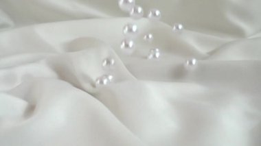 İnciler ipeğe düşer. Yavaş çekim.