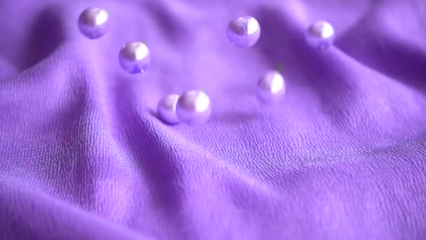 真珠は青い布に落ちる スローモーション — ストック動画