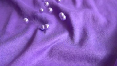 İnciler mavi bir kumaşa düşer. Yavaş çekim.