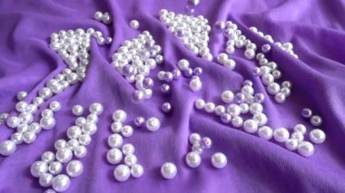 İnciler mavi bir kumaşa düşer. Yavaş çekim.