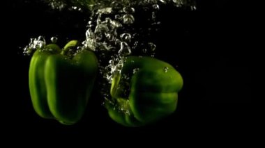 Tatlı biber döküyorum. Ağır çekim. Siyah arkaplan.