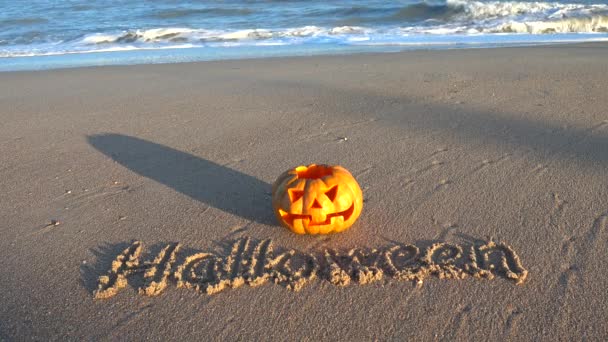 Läskig Halloweenpumpa Inskriptionen Halloween Sanden Havet Stranden Hav Och Vågor — Stockvideo