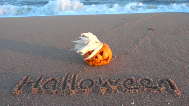 Läskig Halloweenpumpa Inskriptionen Halloween Sanden Havet Stranden Hav Och Vågor — Stockvideo