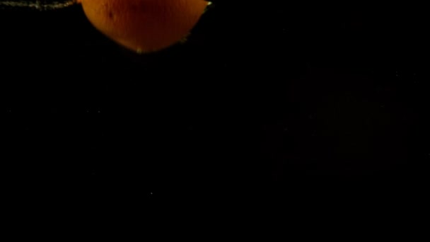 レモンとオレンジの水に落ちる スローモーション 黒の背景 — ストック動画