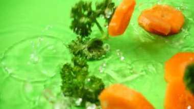 Havuç ve maydanoz segmentlerinin dökülmesi. Yavaş çekim.