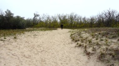 Kız bir patikaya gidiyor. Sonbaharda çekim..