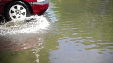 Yağmurdan sonra şehirde sel. Arabalar caddenin aşağısına gidiyor. Yavaş çekim.