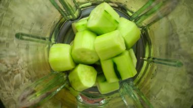 Blender 'da salatalık ezme. Ağır çekim. Blender 'da smoothie hazırlığı. Üst görünüm.