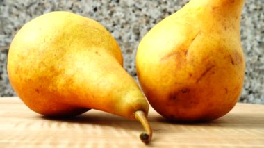 Ahşap mutfak tahtasındaki armutlar. Harekette çekim..