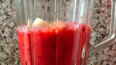 Armut, ahududu ve muzların karıştırıcısını dolduruyorum. Blender 'da smoothie hazırlıyorum..