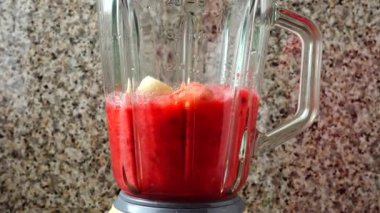 Armut, ahududu ve muzların karıştırıcısını dolduruyorum. Blender 'da smoothie hazırlıyorum..