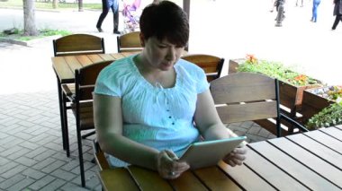 Kafedeki tabletli kız. Yazın çekim..