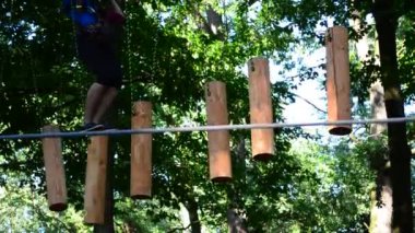 Ergenlik çağındaki kız ağaçlar arasındaki engelleri aşıyor. Yazın çekim..