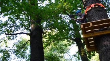 Ergenlik çağındaki kız ağaçlar arasındaki engelleri aşıyor. Yazın çekim..
