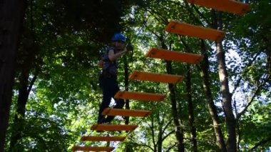 Ergenlik çağındaki kız ağaçlar arasındaki engelleri aşıyor. Yazın çekim..