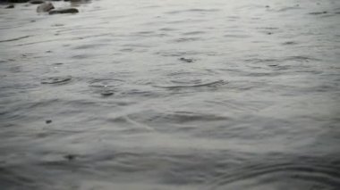 Dağ nehrine yağmur yağıyor. Yavaş çekim.