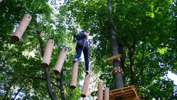 Das Mädchen Überwindet Hindernisse Zwischen Bäumen Der Höhe Dreharbeiten Sommer — Stockvideo