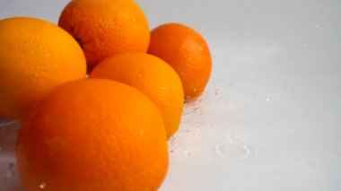 Sulu portakallar ve su sıçramaları. Yavaş çekim.