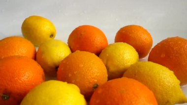 Sulu portakallar, limonlar ve su sıçramaları. Yavaş çekim.