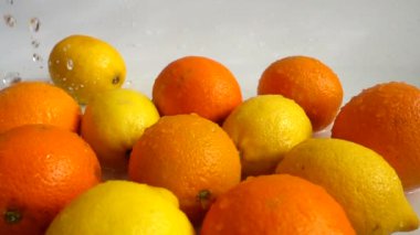 Sulu portakallar, limonlar ve su sıçramaları. Yavaş çekim.