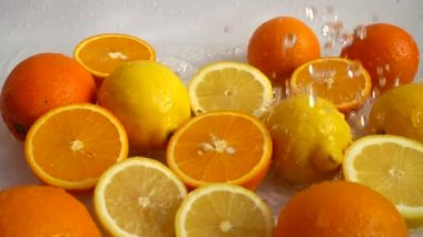 Sulu portakallar, limonlar ve su sıçramaları. Yavaş çekim.
