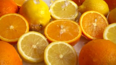 Sulu portakallar, limonlar ve su sıçramaları. Yavaş çekim.