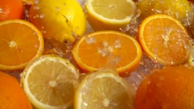 Sulu portakallar, limonlar ve su sıçramaları. Yavaş çekim.