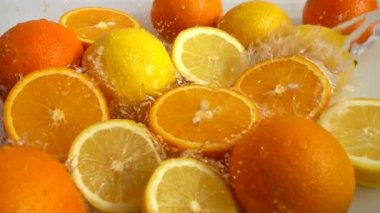 Sulu portakallar, limonlar ve su sıçramaları. Yavaş çekim.