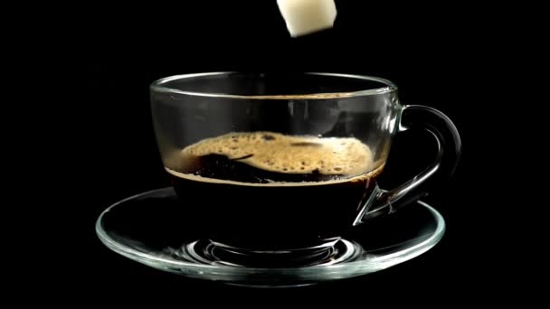 A cukor beleesik egy csészébe a kávéból. Lassú mozgás..
