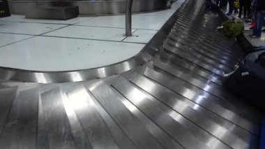 Havaalanından bavul alıyorum. Yolcular vardıktan sonra bagajlarını bekliyorlar..