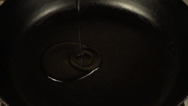加熱された鋳鉄鍋にひまわり油が流れます スローモーション 調理工程 — ストック動画