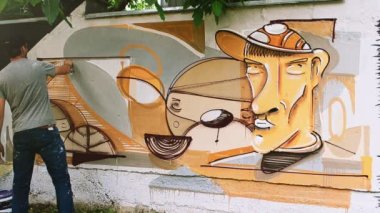 Sanatçılar çitlere grafiti çiziyor. Soyut çizim.
