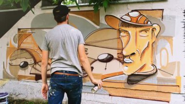 Sanatçılar çitlere grafiti çiziyor. Soyut çizim.