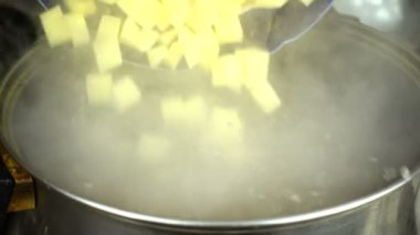 Çorba hazırlığı. Patatesleri çorbaya dök. Yavaş çekim.