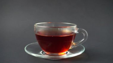 Limon parçaları çayla birlikte bir fincana düşer. Yavaş çekim.