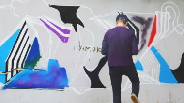 Sanatçı çitlere grafiti çiziyor. Soyut çizim. Ressam çitlere grafiti çiziyor..