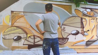 Sanatçı çitlere grafiti çiziyor. Soyut çizim.