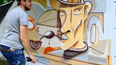 Sanatçı çitlere grafiti çiziyor. Soyut çizim.
