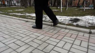 Adam cadde boyunca gidiyor. Parkta çekim..