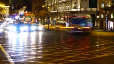 Gece Madrid 'de Alkala ve Gran Via caddelerinin kesişiminde. Zaman ayarlı. Madrid 'de gece trafiği. İspanya 'da çekim. Arka planda Alkal 'ın kapısı görünür.