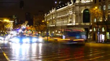 Gece Madrid 'de Alkala ve Gran Via caddelerinin kesişiminde. Zaman ayarlı. Madrid 'de gece trafiği. İspanya 'da çekim. Arka planda Alkal 'ın kapısı görünür.