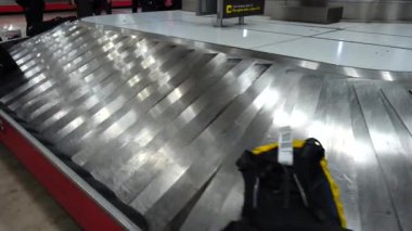 Havaalanından bavul alıyorum. Yolcular vardıktan sonra bagajlarını bekliyorlar..