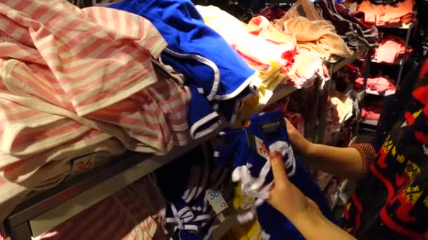 ヨーロッパの店舗で買い物 少女は服を選ぶ — ストック動画