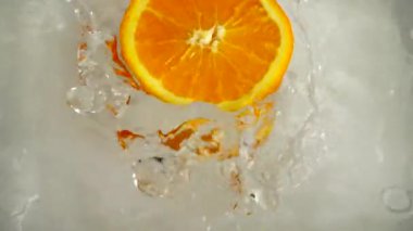 Portakallar suya düşüyor. Yavaş çekim.